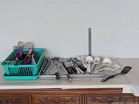 Overview of all utensils on countertop including dish rack, rulers, cleavers, serving spoons