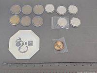 Full lot showing 10 capped tokens, 2 bagged tokens, octagonal mirror and scale
