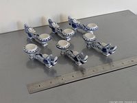 All six porcelain spoon rests aligned with ruler for scale