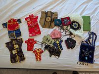 Group shot of all pouches, beaded bag and wallet on white surface