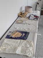 Overall shot of linens, doilies, napkins, basket on table