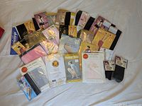 Full lot of sealed vintage pantyhose spread out on white background