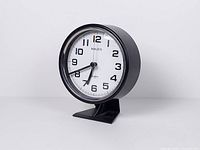 Front left angled view of clock showing body, base and dial