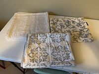 Three folded textiles displayed on table