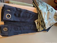 Stacked navy grommet-top panels beside teal floral panels