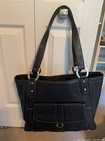 Front view showing exterior pocket, buckle and dual straps