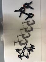 Full set of clamps laid out: 4 C-clamps, 11 spring clamps