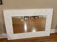 Front view of white hand-carved rectangular mirror