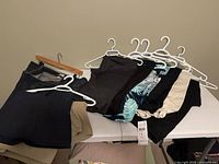 Overall lot of pants and skorts on hangers and folded on table