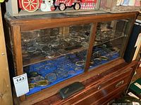 Front view of wood display case filled with eyeglasses