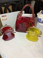 Group shot of three glass purse vases showing sizes and colors
