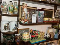 Full view of shelves showing liquor jugs, immortal figurine, framed prints, tins, horse and buggy, egg jar