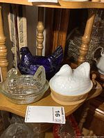 All three glass hen-on-nest dishes on shelf