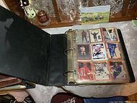 Binder open showing one page of nine hockey cards in plastic sleeves