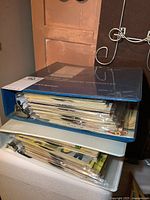 Two stacked blue binders filled with record/book sets