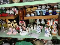 Wide view of shelf showing numerous novelty salt and pepper shaker sets in various shapes and materials
