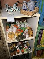 Full view of shelving unit showing three levels of assorted salt and pepper shakers