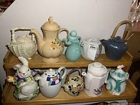 Group of ten assorted teapots on two shelves