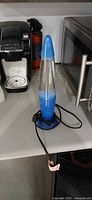 Full view of blue lava lamp showing base, cap and cord