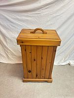Front view of honey-finished wooden chest with lid and handle