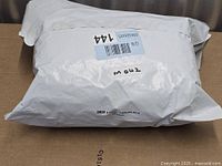 Sealed white shipping bag labeled M 042 containing Boshen camouflage netting