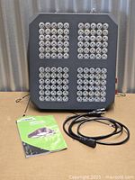 Front view of LED grow light with power cord and manual