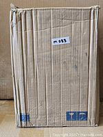 Sealed cardboard shipping box containing the Quoizel Nicholas bath fixture, model label not visible