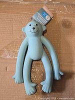 Front view of light blue monkey squeaky toy showing full shape and tag attached