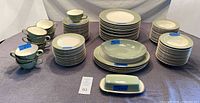 Full assortment of Classic Heritage Green dinnerware showing plates, bowls, cups, platters and butter dish