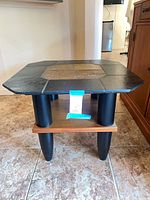 Full view of table showing slate tile top, legs, and wood shelf