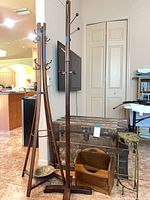 Overall view showing both coat trees, steamer trunk, magazine rack, plant stand