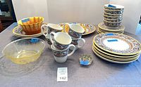 Stoneware dinner and salad plates, bowls, mugs plus two glass bowls and flower frog displayed