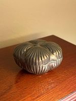 Front angled view of silver-tone floral trinket box closed