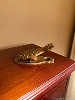 Top view of brass pineapple clip closed on wood surface