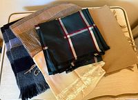 Stack of five scarves showing patterns, colors and fringes