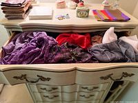 Drawer filled with multiple scarves showing colors and textures