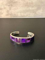 Front view of sterling cuff showing purple sugilite inlay pattern