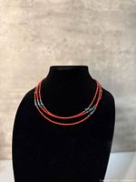Full necklace displayed on bust showing triple strands and bead pattern