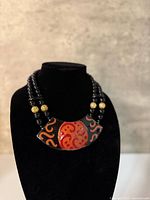 Front view showing necklace on bust, enamel pendant and beads