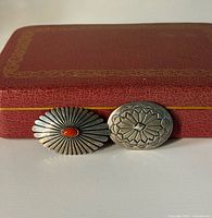 Front view showing both brooch faces: oval with coral, round stamped design