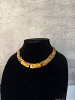 Front view of copper enamel link necklace on display bust