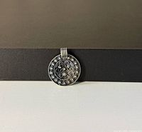 Front view of round filigree sterling pendant