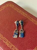 Front view of lapis lazuli and silver dangle earrings showing stone color, silver details, post backs