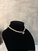 Full view of pearl strand on bust, clasp centered