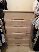 Front view of five-drawer chest showing handles and wood grain