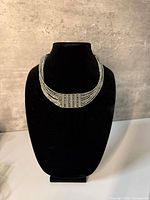 Front view of vintage silver-tone 10-strand necklace on display bust