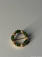 Front view of circular jade and pearl brooch