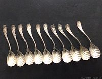 Ten sterling silver spoons aligned bowl down