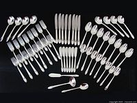 Full 57-piece First Love flatware set arranged on black background
