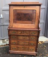 Front view showing closed fall-front and drawers